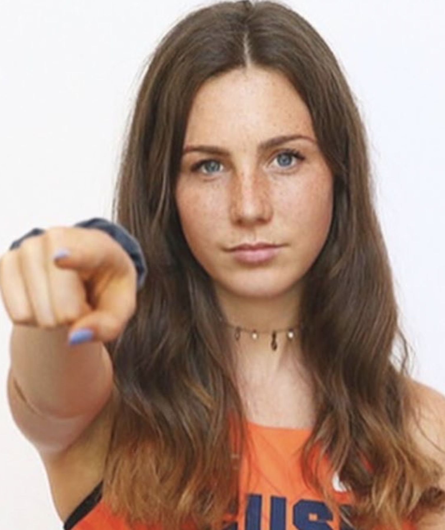 Runner in an orange top pointing at the camera